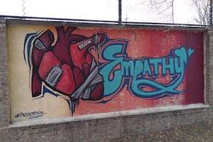 Graffiti on school playground wall reading Empathy