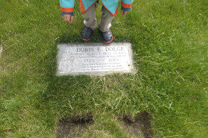 child standing at gravestone